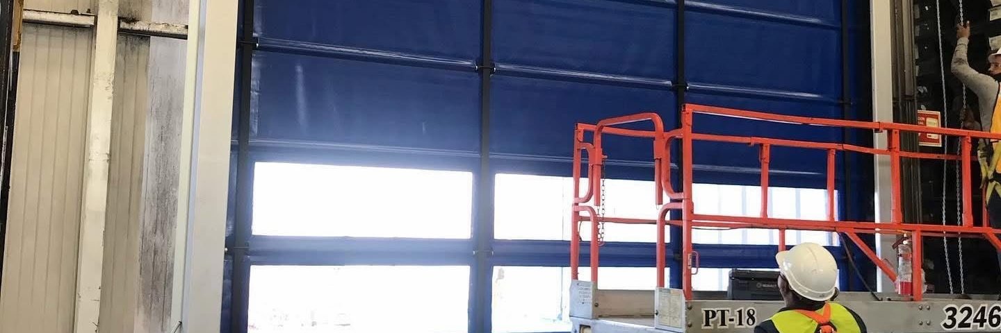 Mantenimiento de cortina rápida industrial de lona con plataforma de tijera en nave logística